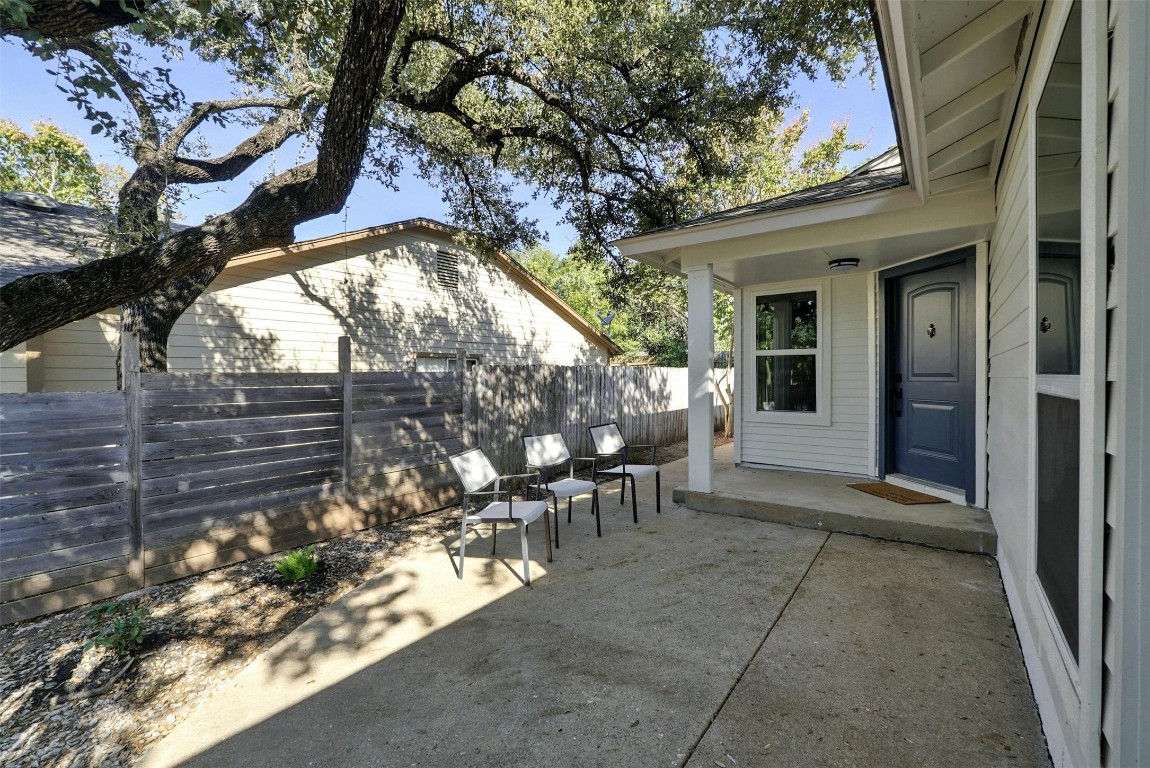 a view of two chairs and table in a patio