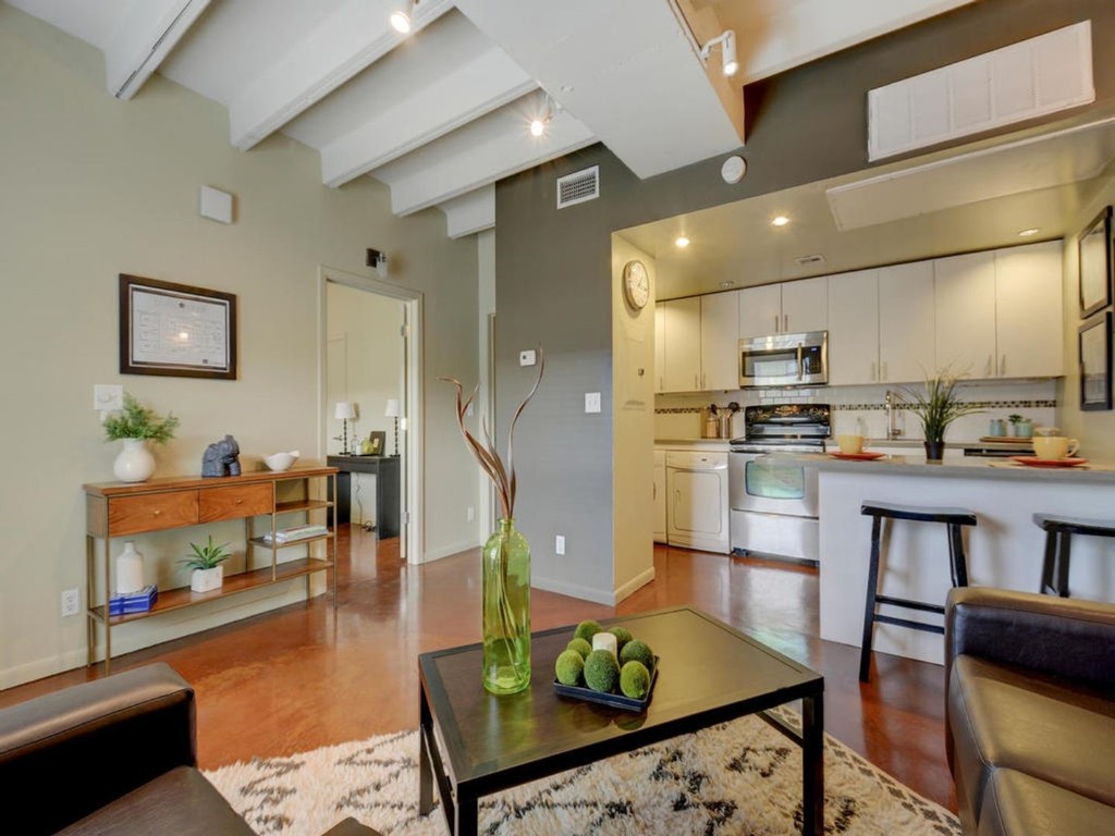 a living room with stainless steel appliances kitchen island granite countertop furniture and a kitchen view