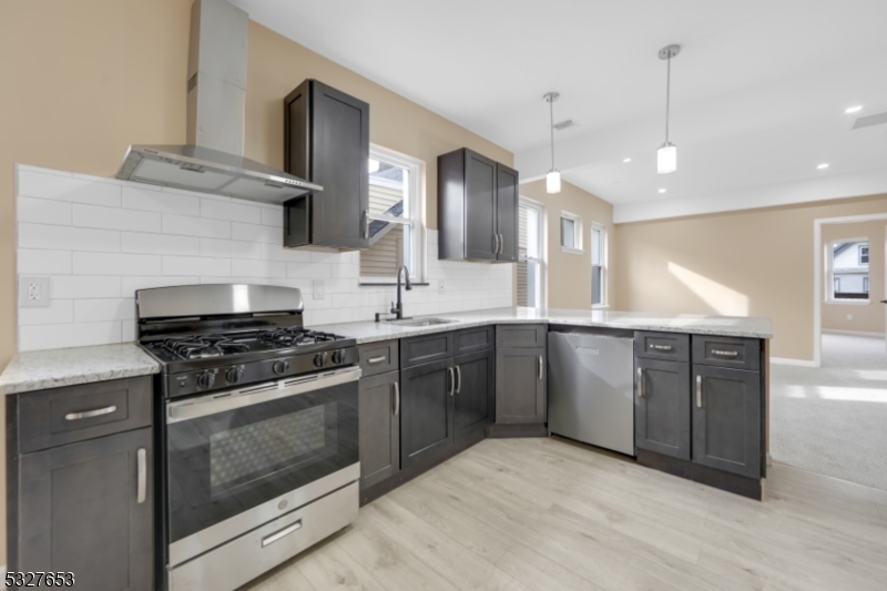 a kitchen with stainless steel appliances granite countertop a stove a sink and a microwave