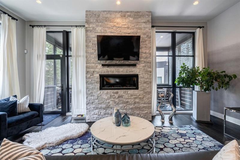 a living room with furniture a fireplace and a potted plant