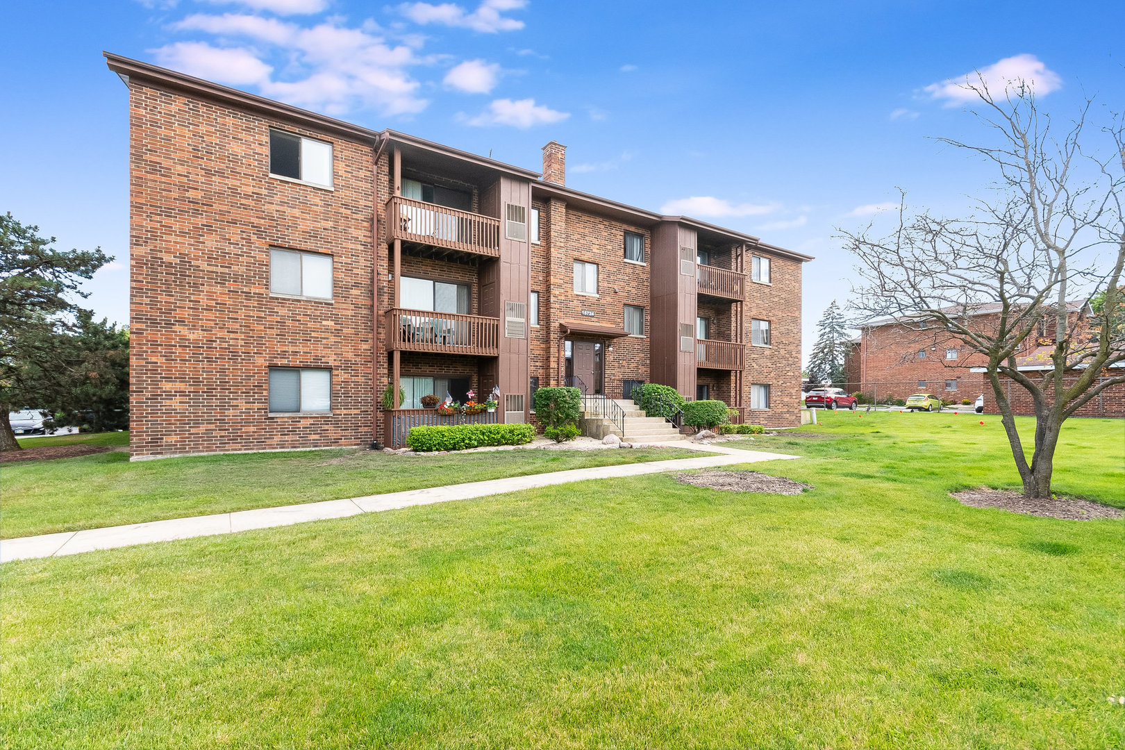 a large brick building with a big yard and large trees