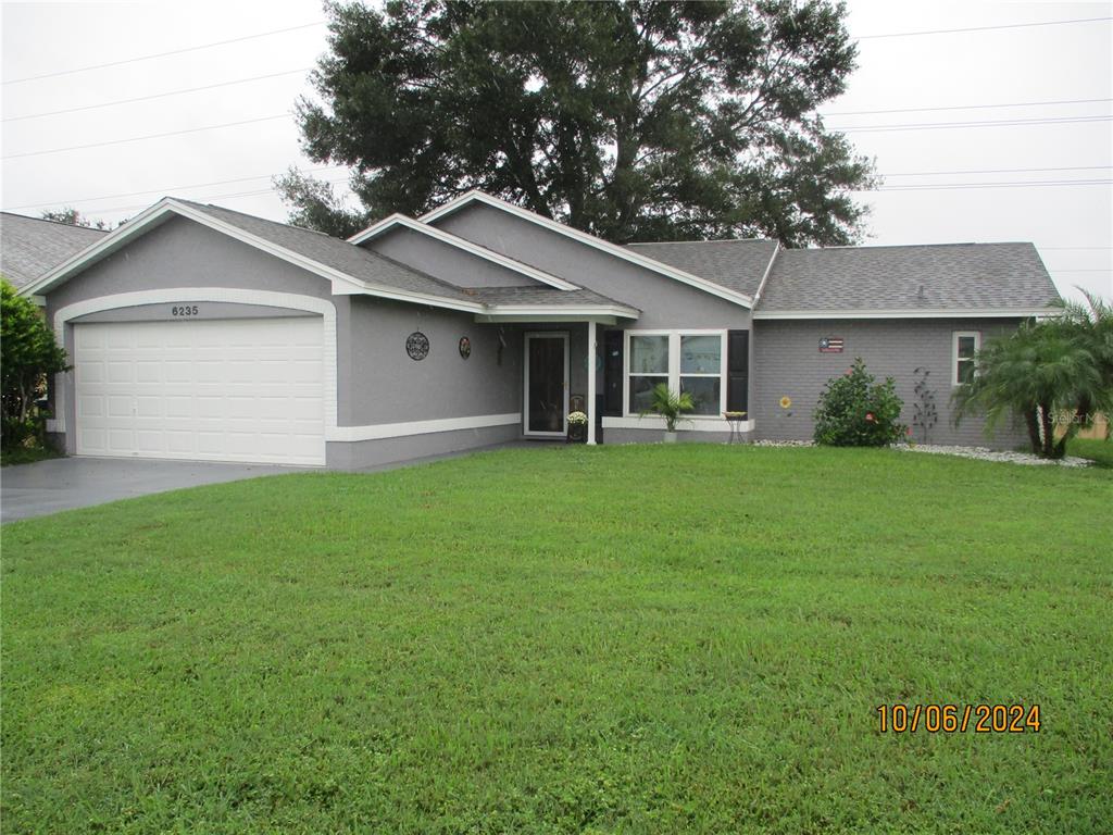 a front view of house with yard and green space