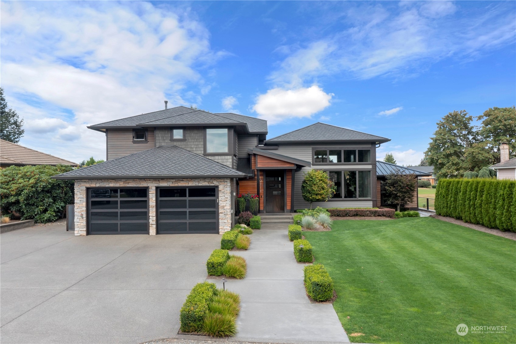 a front view of a house with a garden and yard