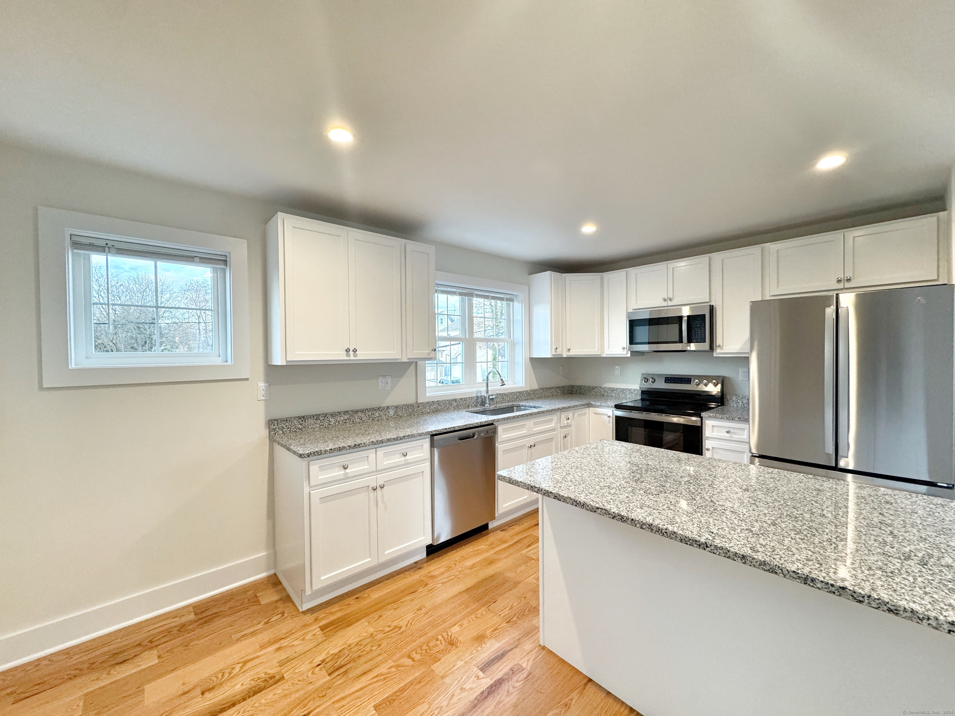 a kitchen with stainless steel appliances granite countertop a stove a sink and a refrigerator