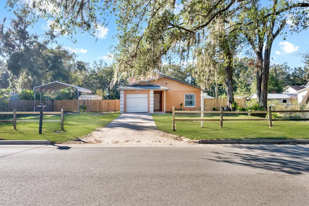 a view of house with backyard and tree s