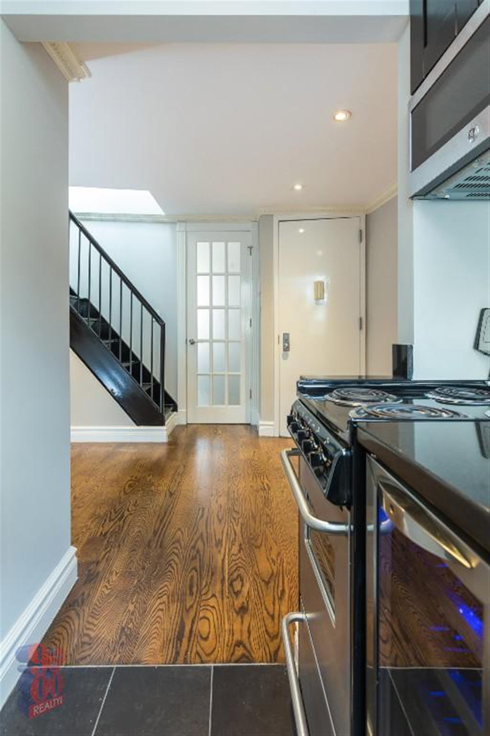 a view of a livingroom with a kitchen and wooden floor