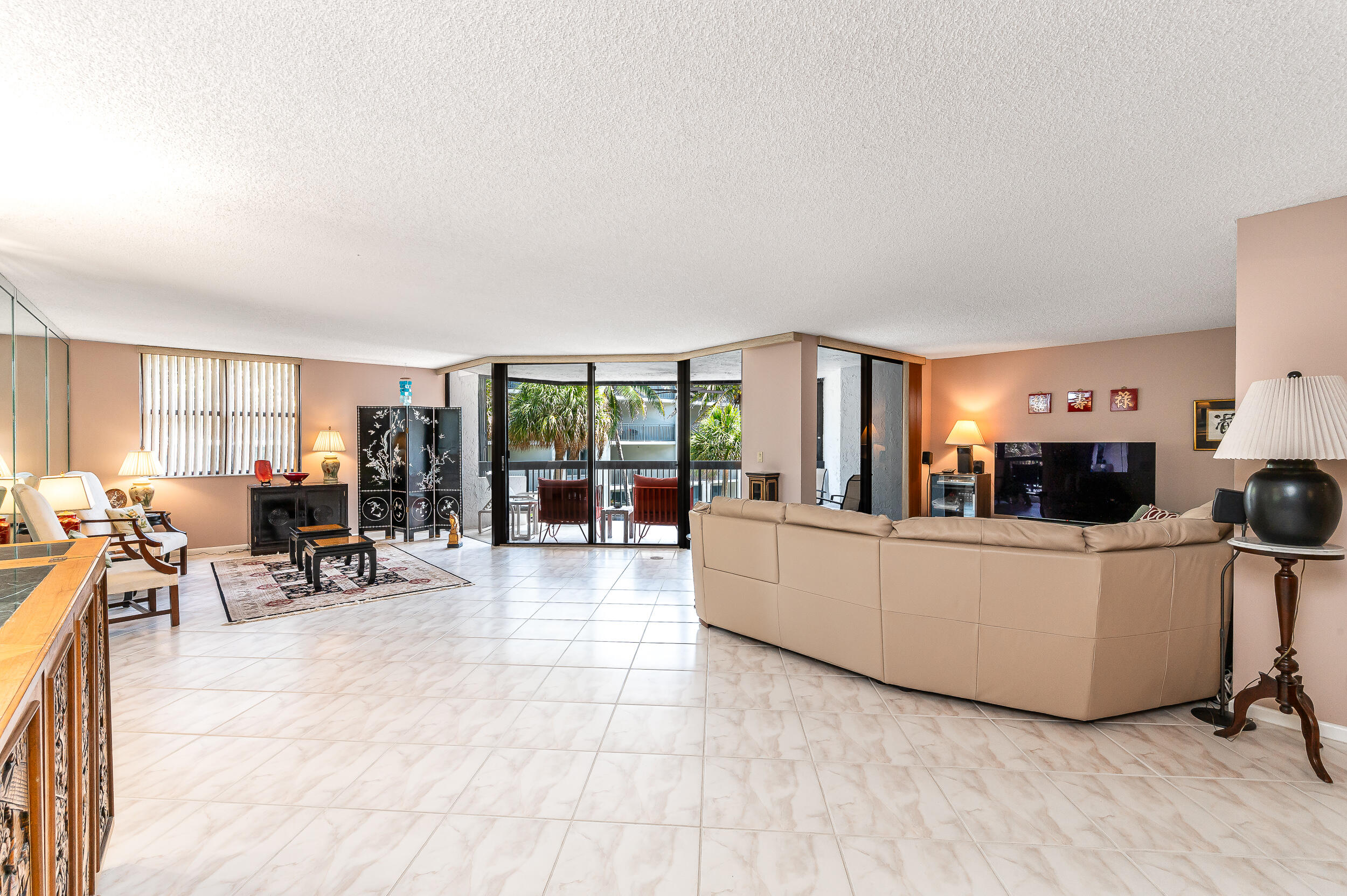 a living room with furniture and a dining table with projector the kitchen