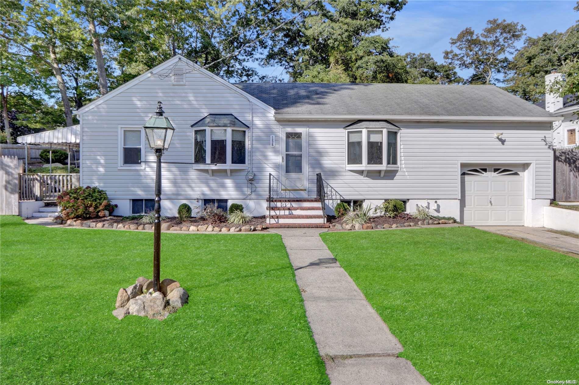 a front view of a house with a garden and yard