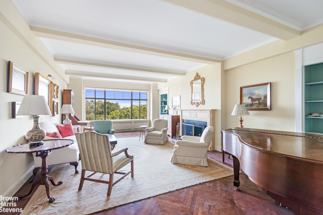 a living room with fireplace furniture and a large window