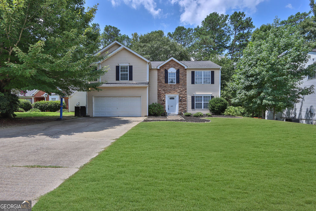 a front view of a house with a yard and garage