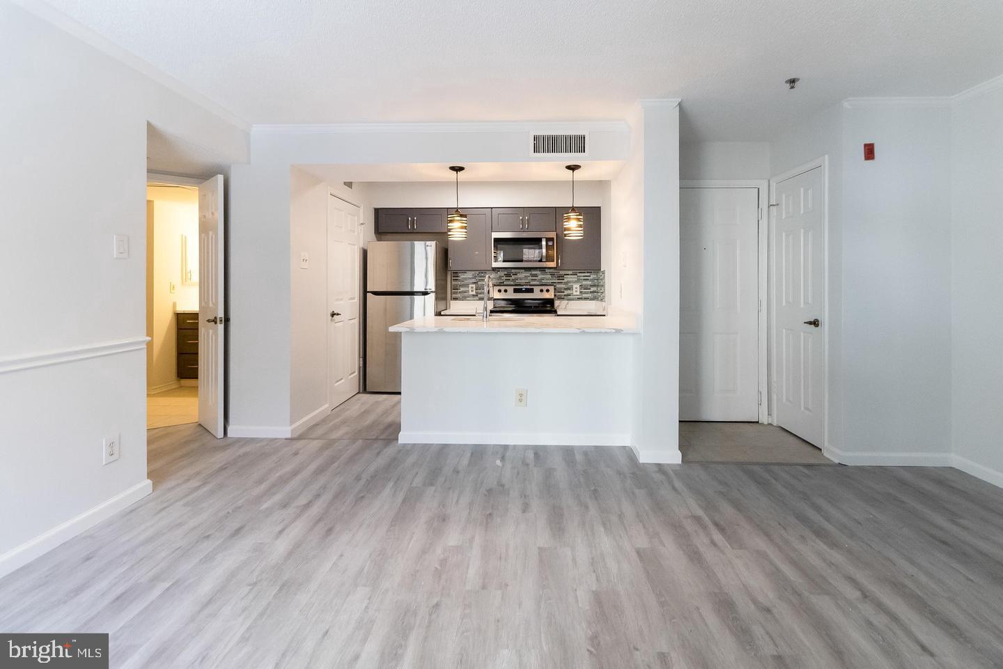 a view of a kitchen with wooden floor and a sink