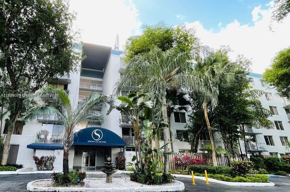 a view of a building with a street and trees