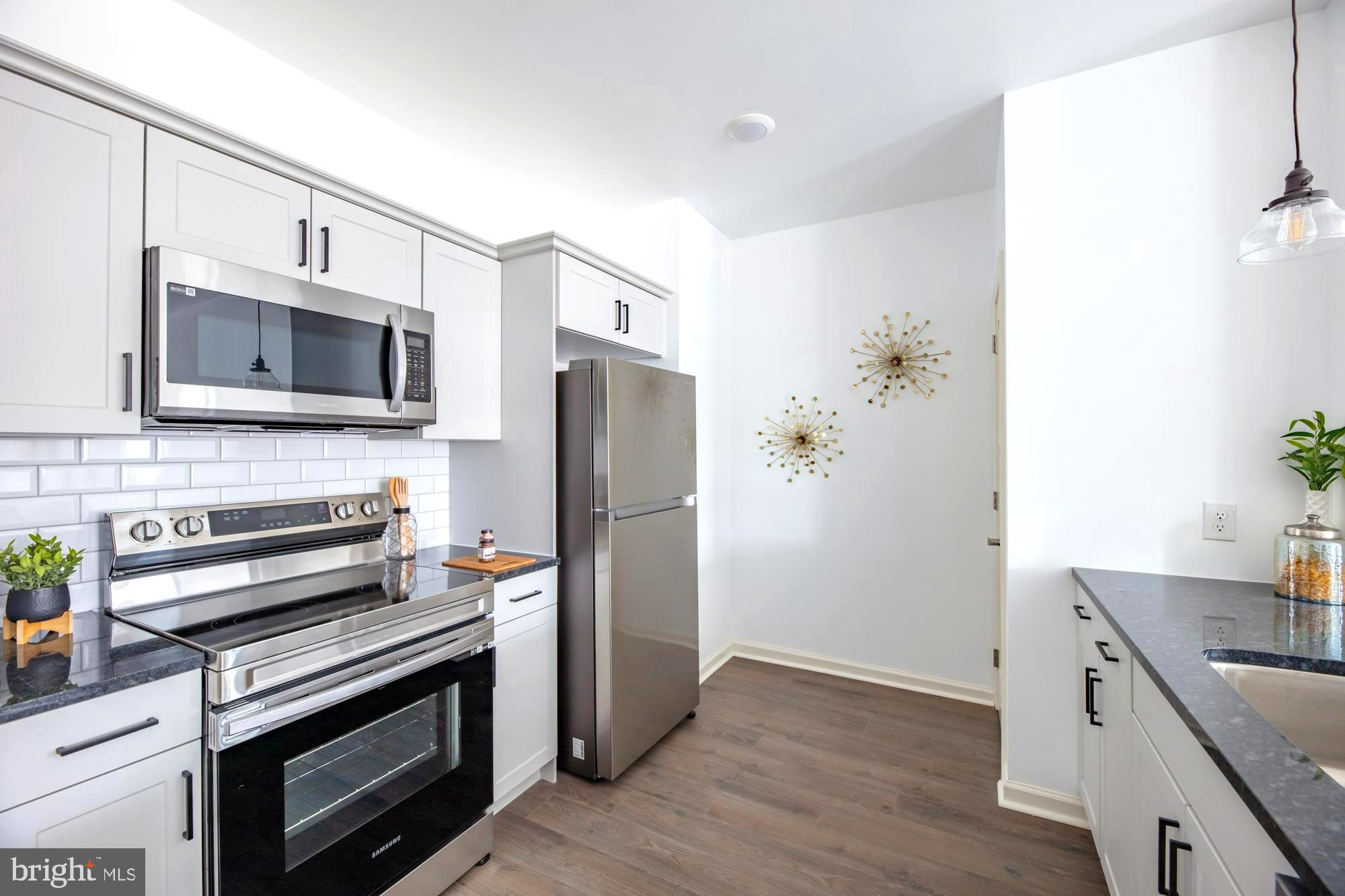 a kitchen with stainless steel appliances a stove microwave and refrigerator