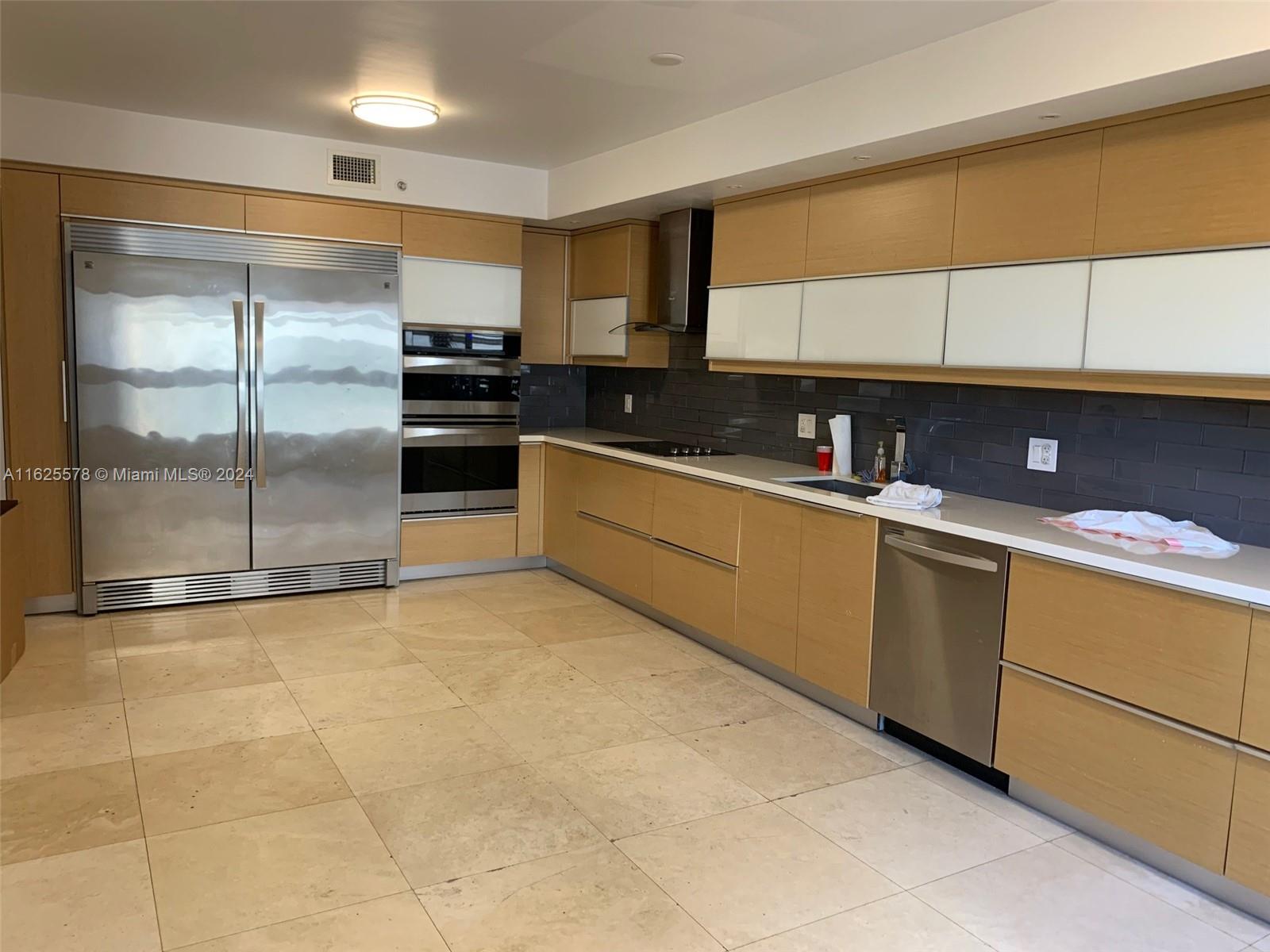 a kitchen with stainless steel appliances granite countertop a refrigerator and a sink