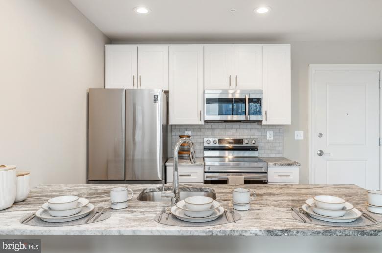 a kitchen with stainless steel appliances kitchen island granite countertop a sink and cabinets