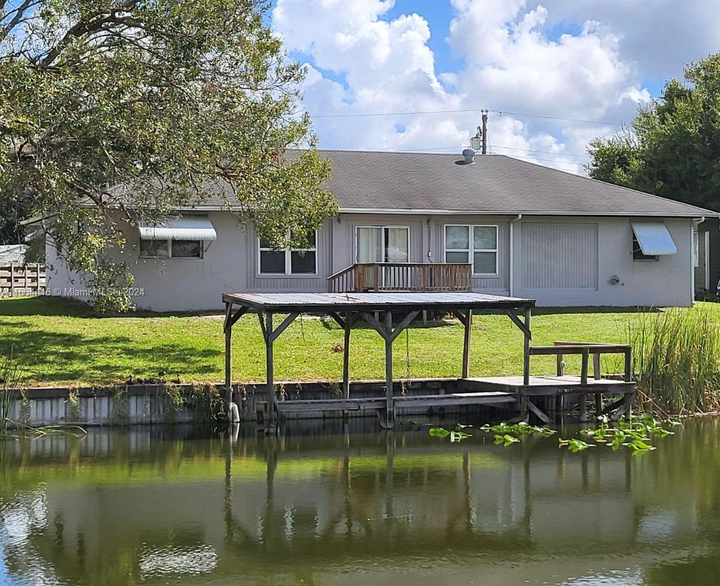 a view of a house with pool and a yard