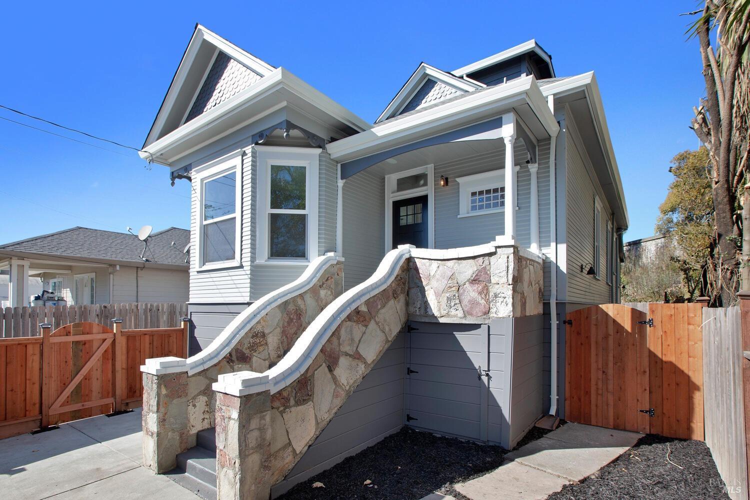 a view of a house with a small yard and wooden floor and fence