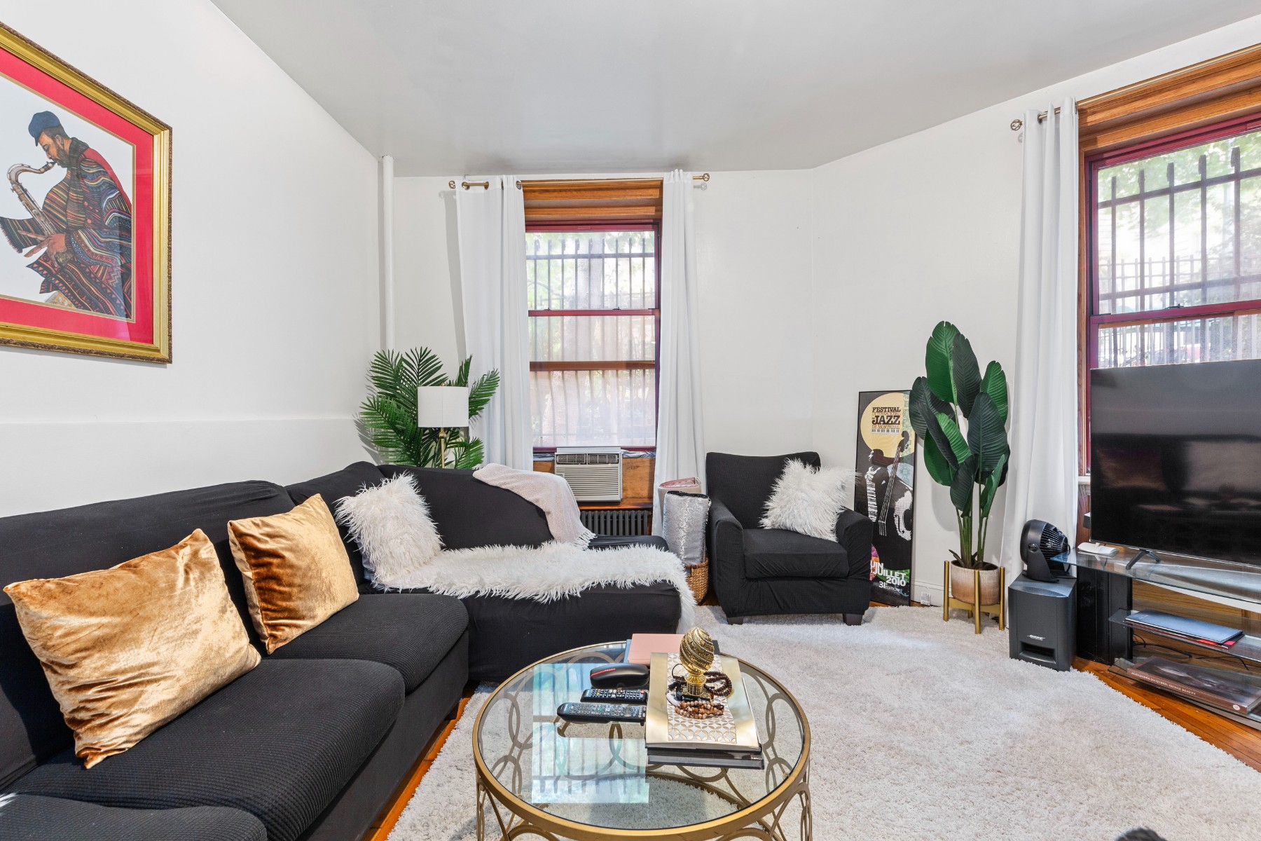 a living room with furniture a window and a flat screen tv