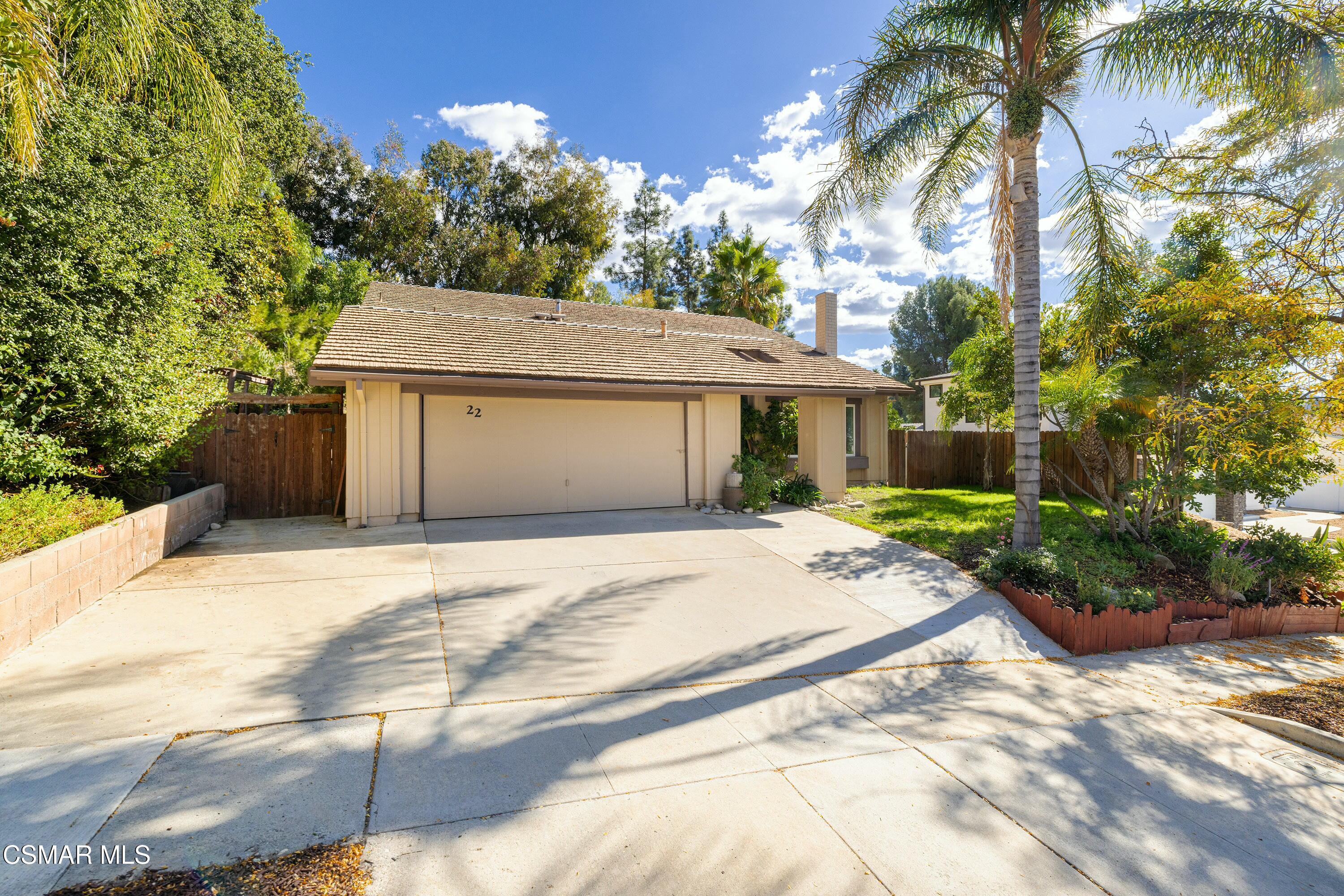 a front view of a house with yard and trees