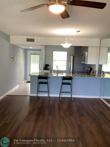 a living room with furniture and a dining table with kitchen view