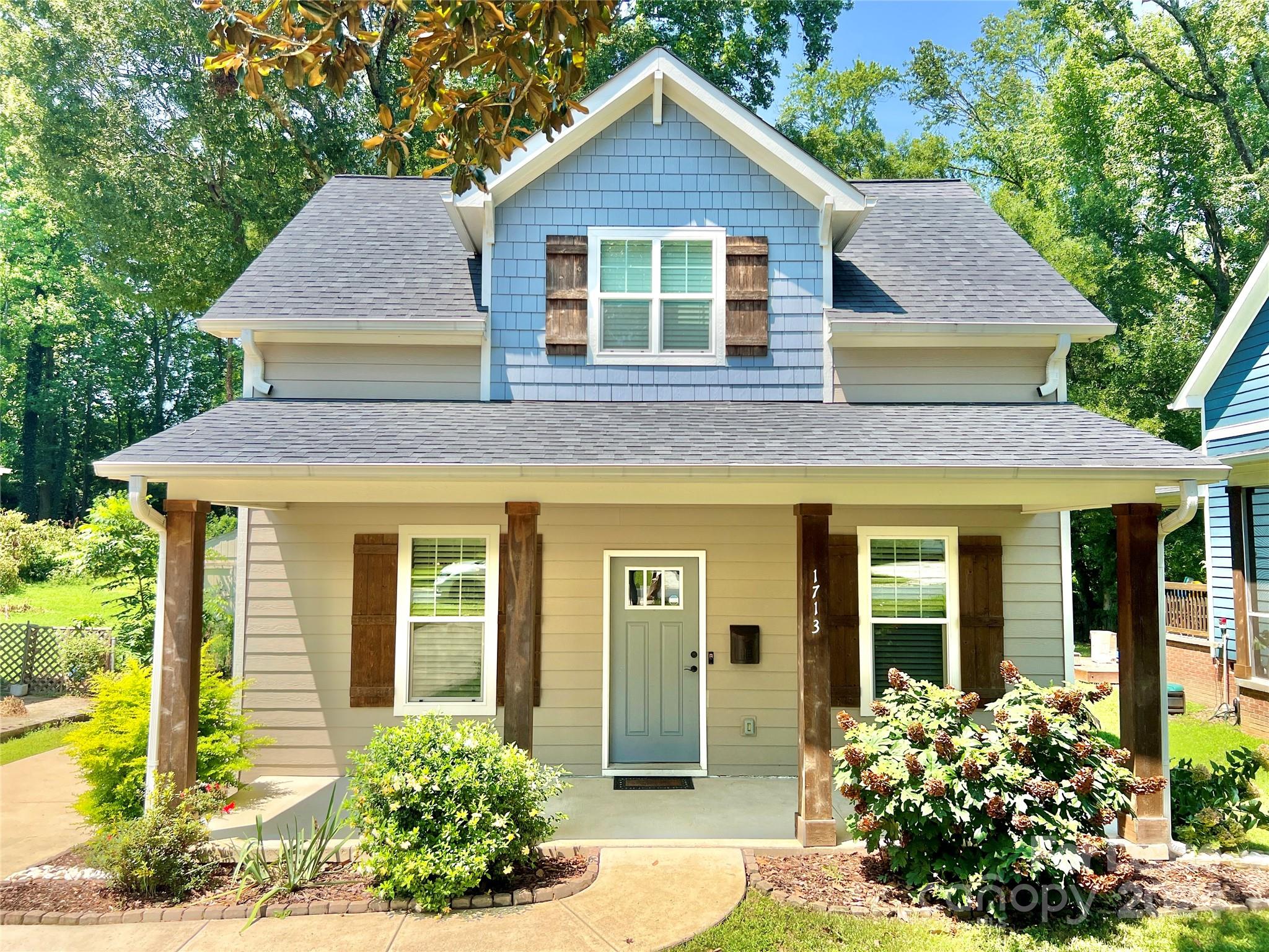 a front view of a house with a yard and potted plants