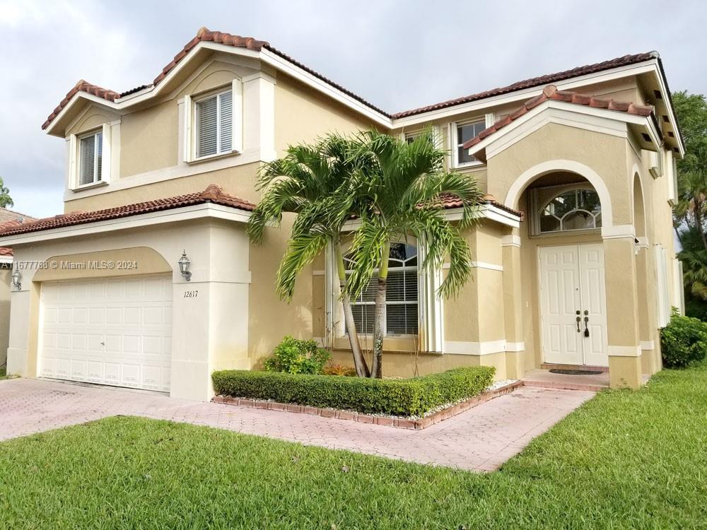 a front view of a house with a yard and garage