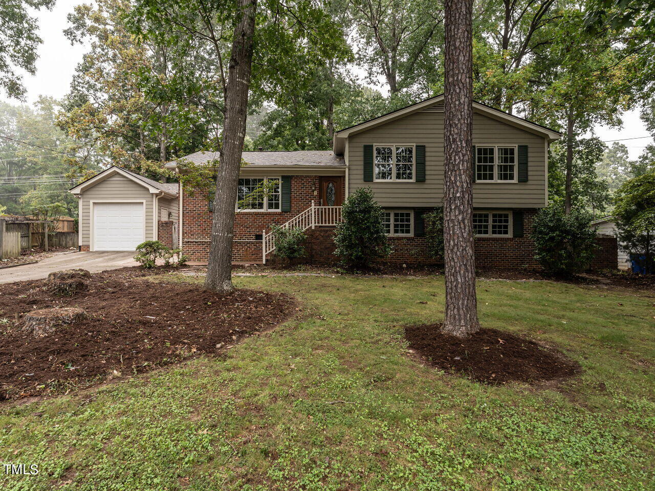 a front view of a house with a yard and trees