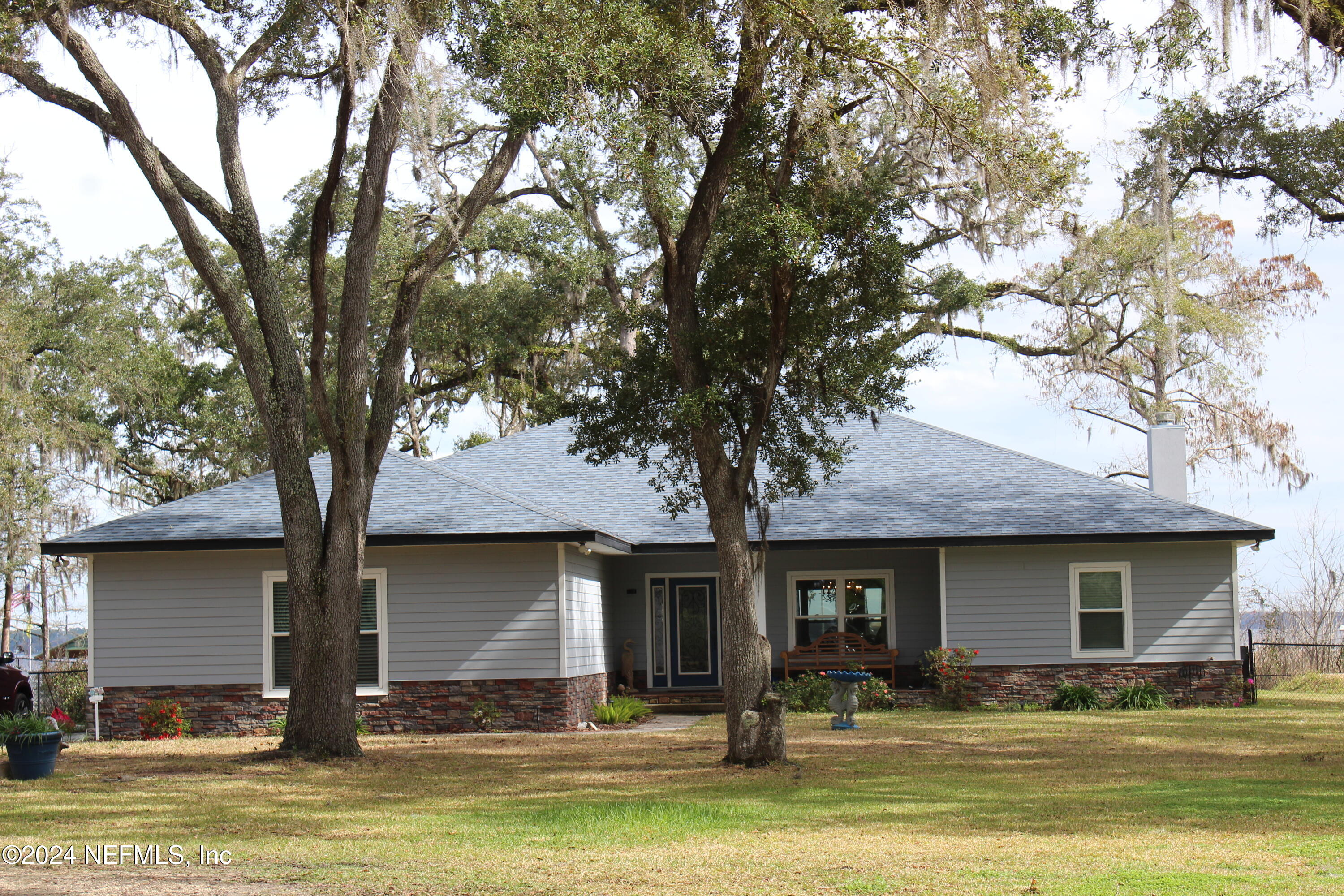 a front view of house with yard and trees around