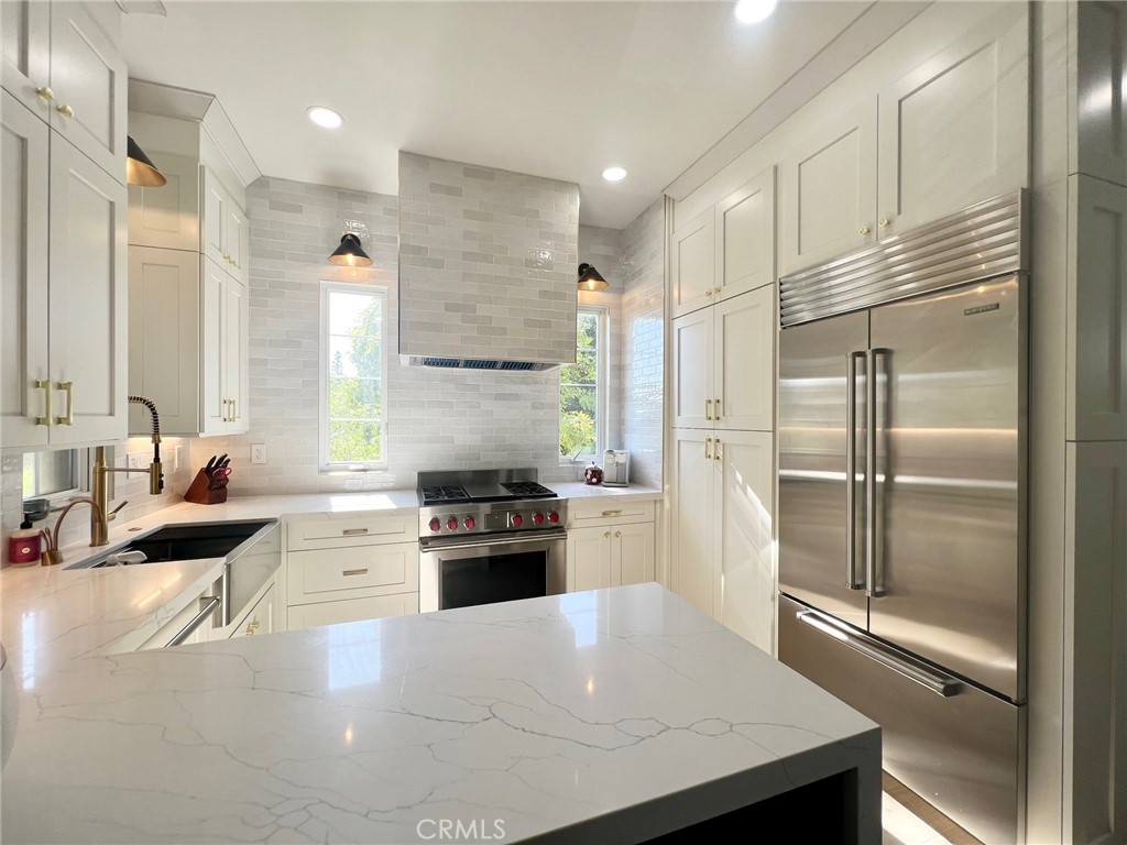 a kitchen with kitchen island a sink stove and refrigerator