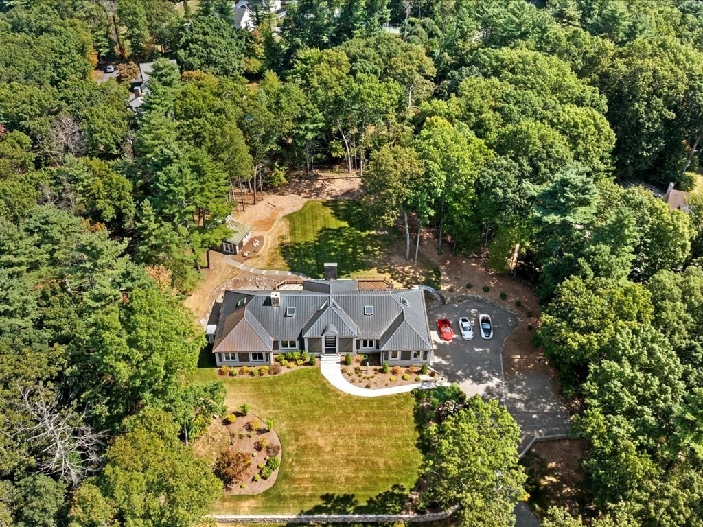 an aerial view of a house with swimming pool a yard and lake view