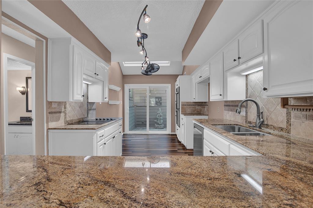 a large kitchen with granite countertop a stove sink and refrigerator