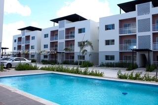 a front view of building and yard with swimming pool