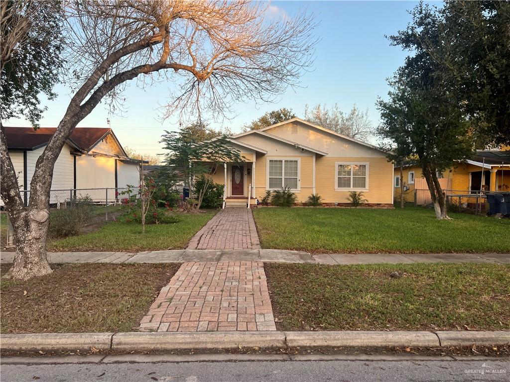 a front view of a house with a yard and trees