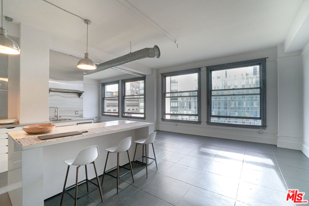 a kitchen with a sink and chairs