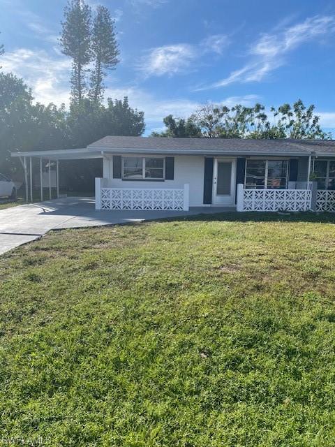 Single story home featuring a carport and a front lawn