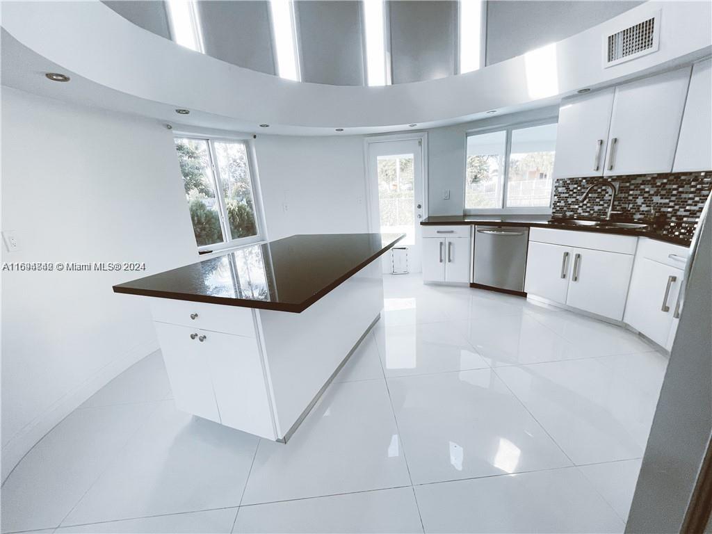 a kitchen with stainless steel appliances a white stove top oven and white cabinets