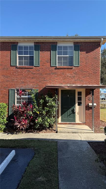 front view of a brick house with a yard