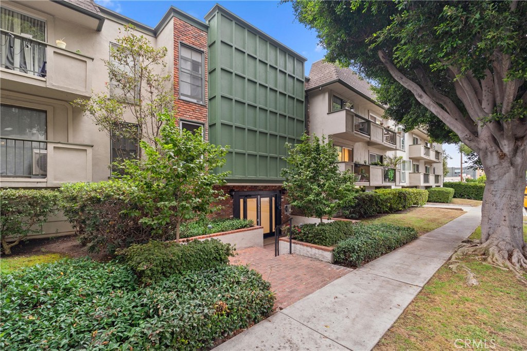 a front view of a multi story building with a yard