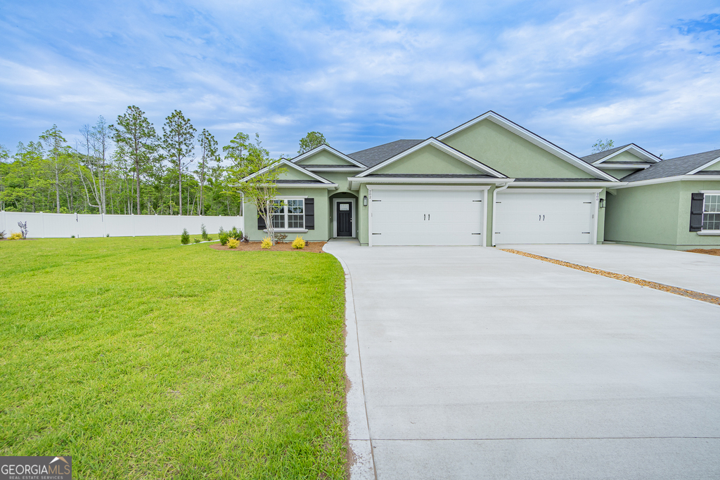 a front view of a house with a yard and garage