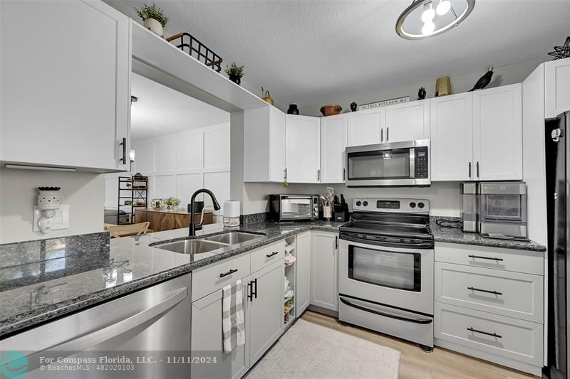 a kitchen with white cabinets stainless steel appliances and sink