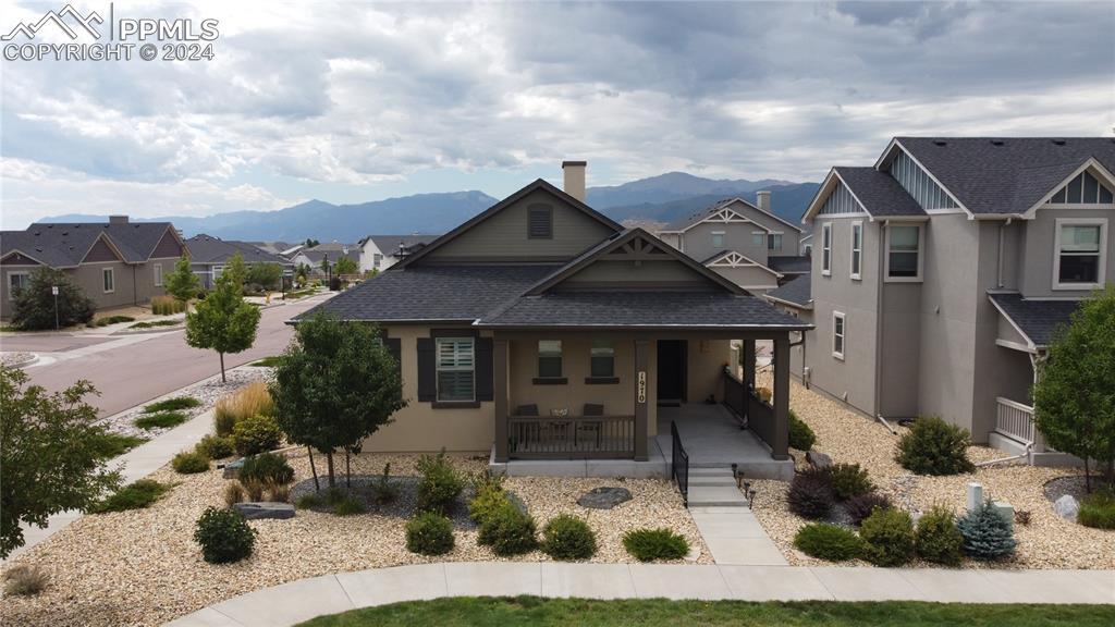 View of front of house with a mountain view, a garage, and covered porch