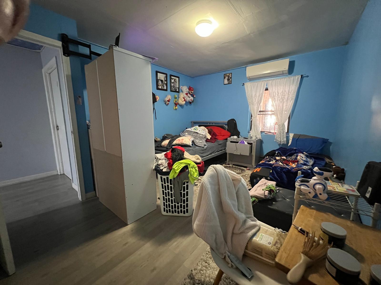 Bedroom with hardwood / wood-style floors and a wall unit AC