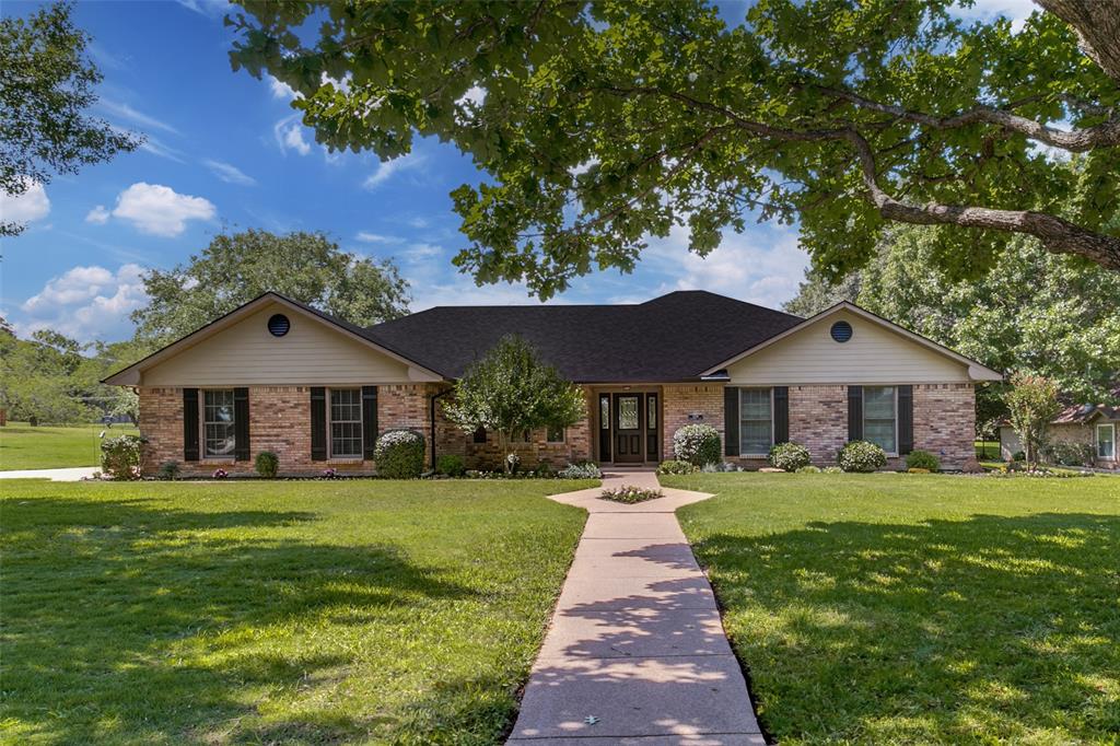 a front view of a house with a yard and trees