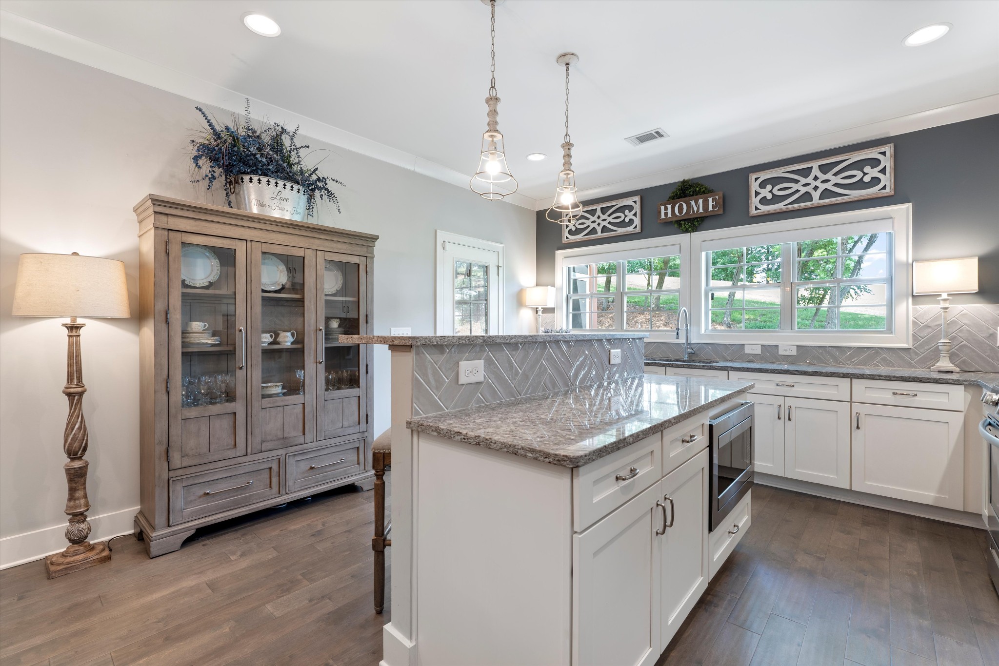 a kitchen with a counter space a sink appliances and a large window