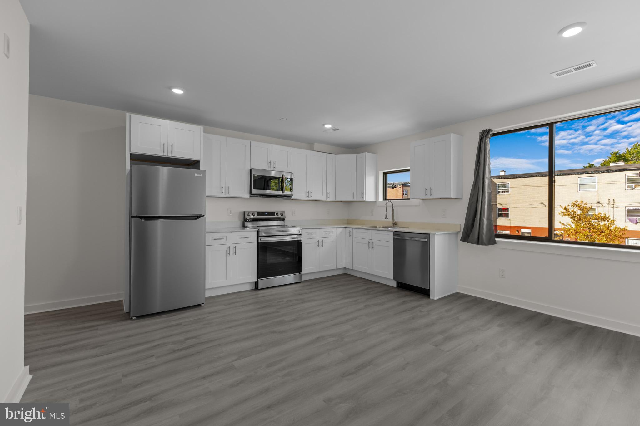 a kitchen with white cabinets and stainless steel appliances