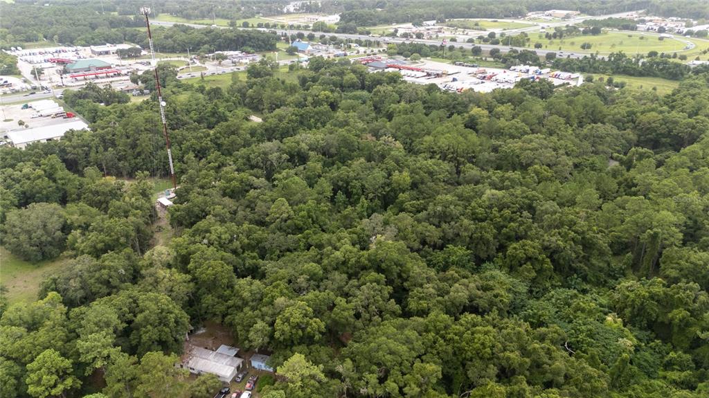 an aerial view of residential houses with outdoor space and trees