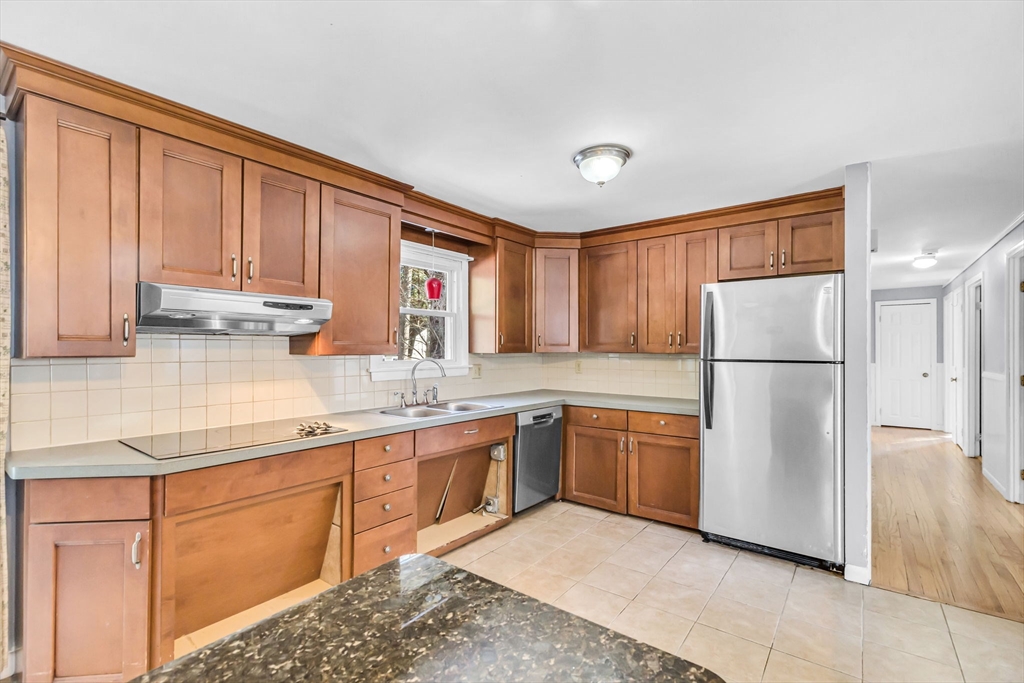 a kitchen with stainless steel appliances granite countertop a refrigerator sink and cabinets