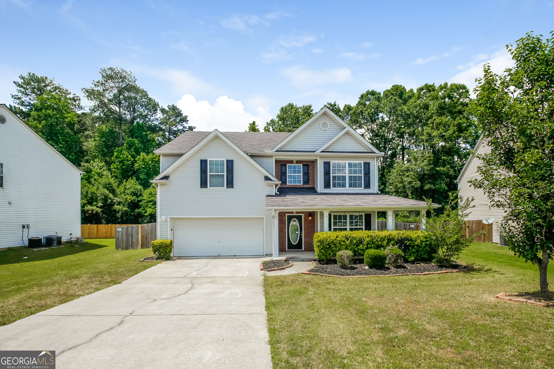 a front view of a house with a yard and trees