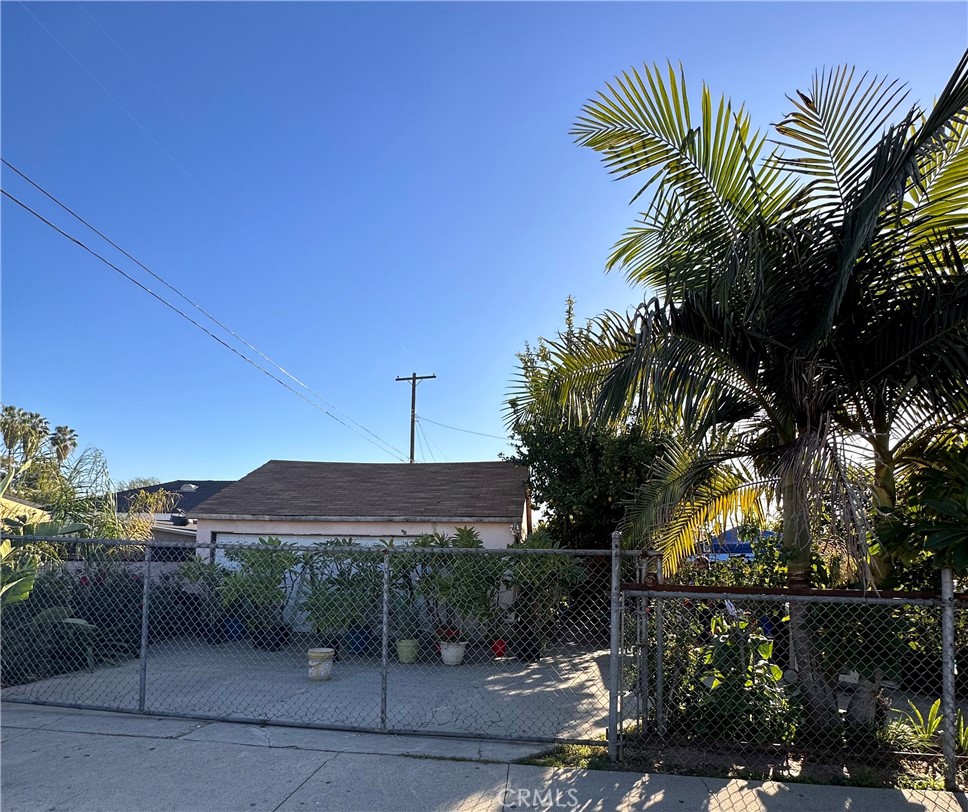 a view of a palm and trees in front of the house