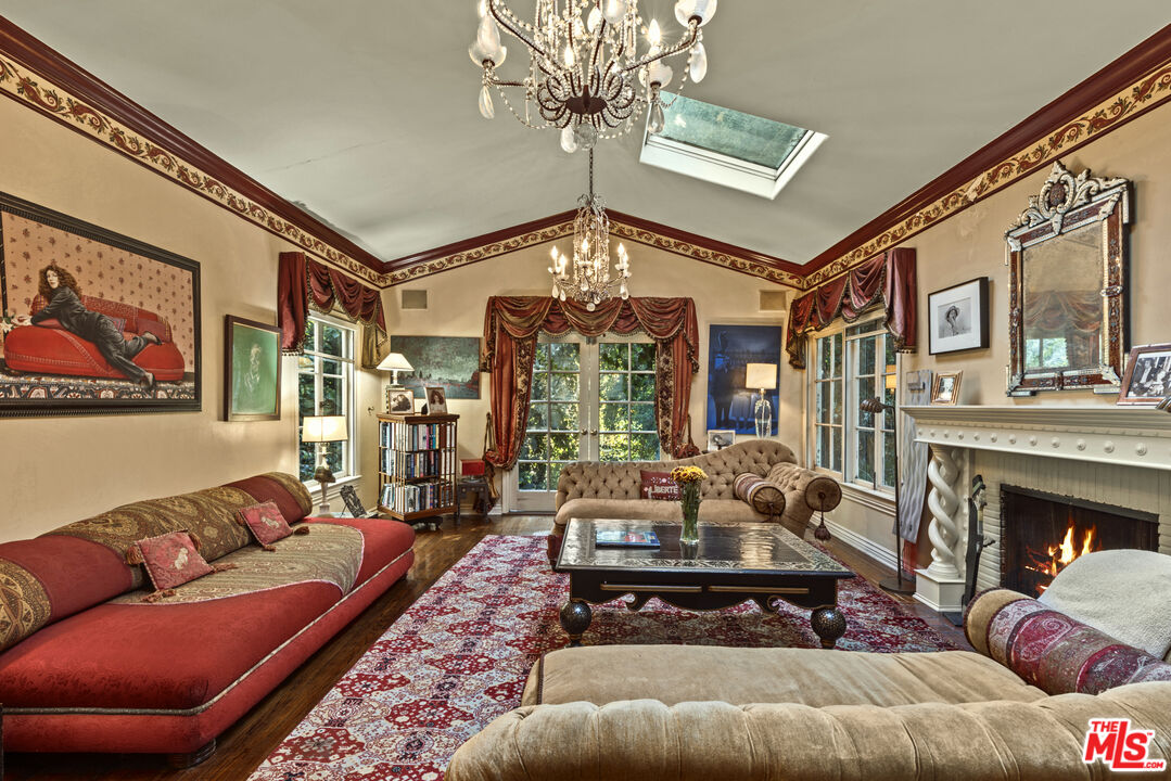 a living room with furniture a chandelier and a fireplace